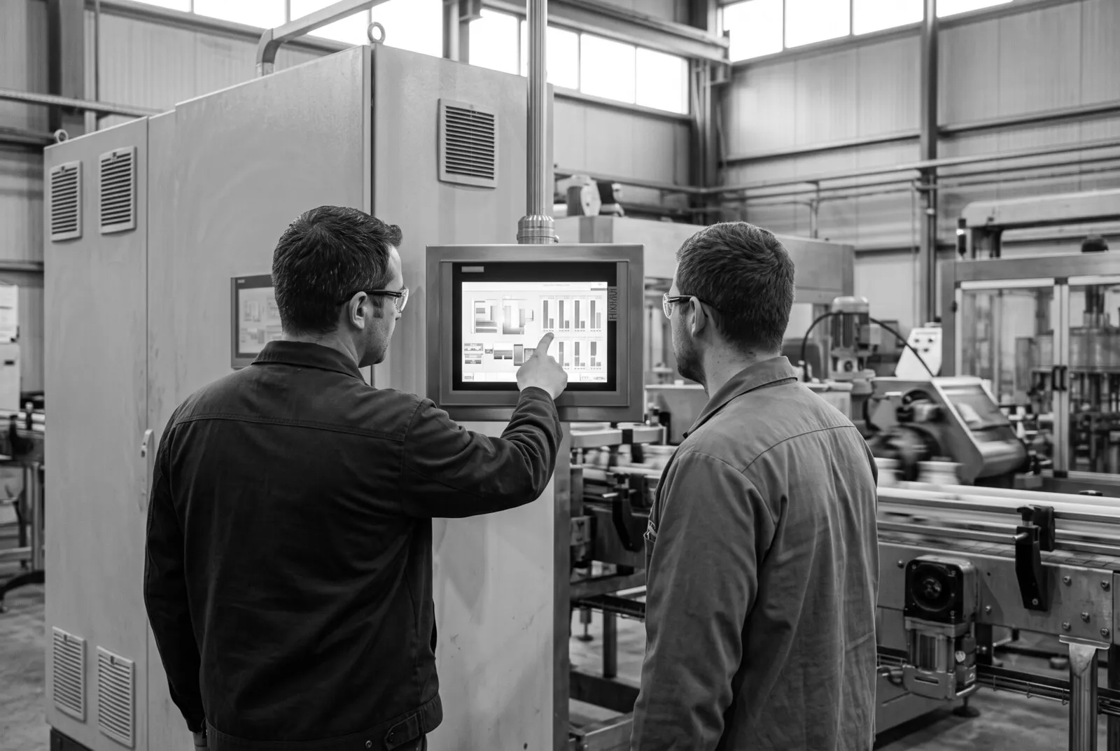 Técnico mostrando la pantalla HMI de un tablero a un operador en planta